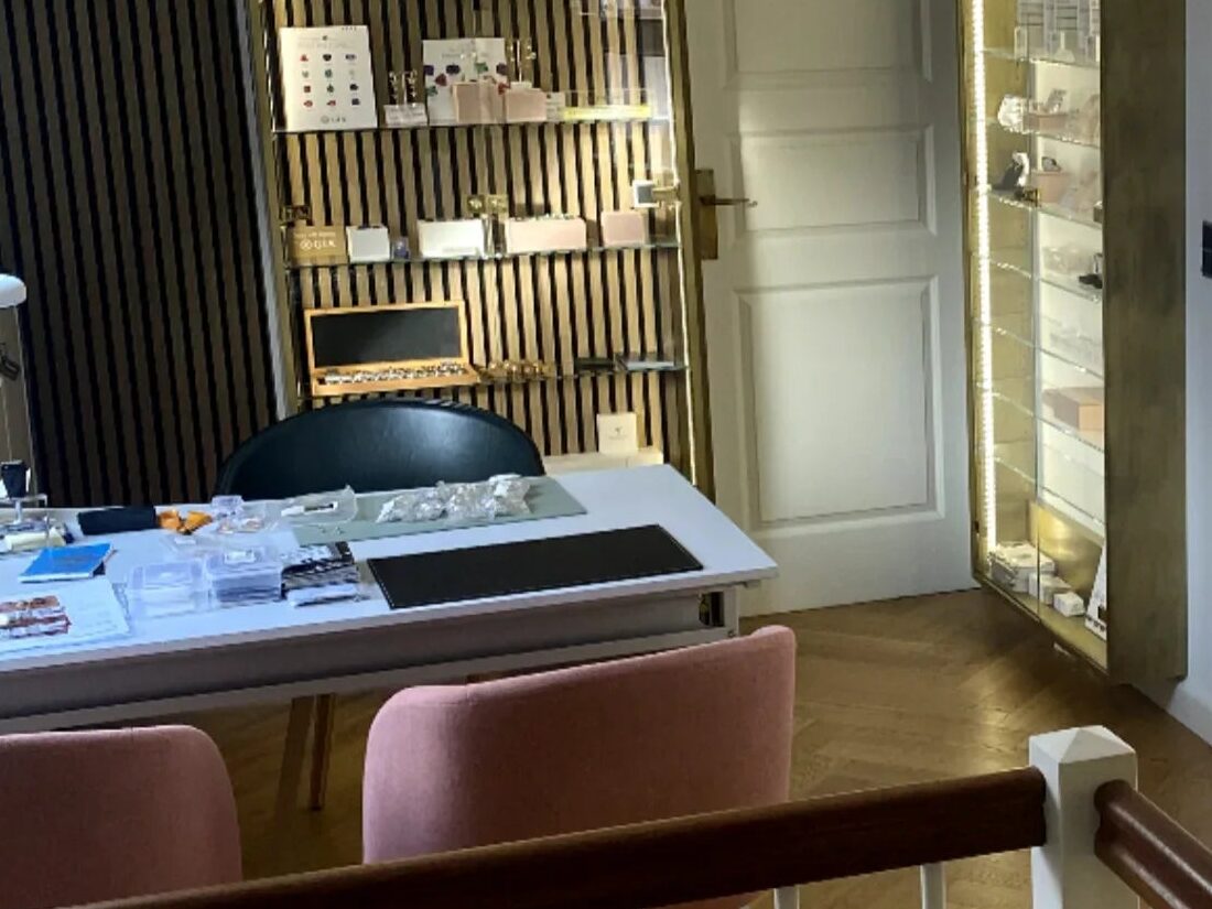 Rådgivningsbordet i MANICHs showroom med løse diamanter, papirer og oplyste montrer bagved
