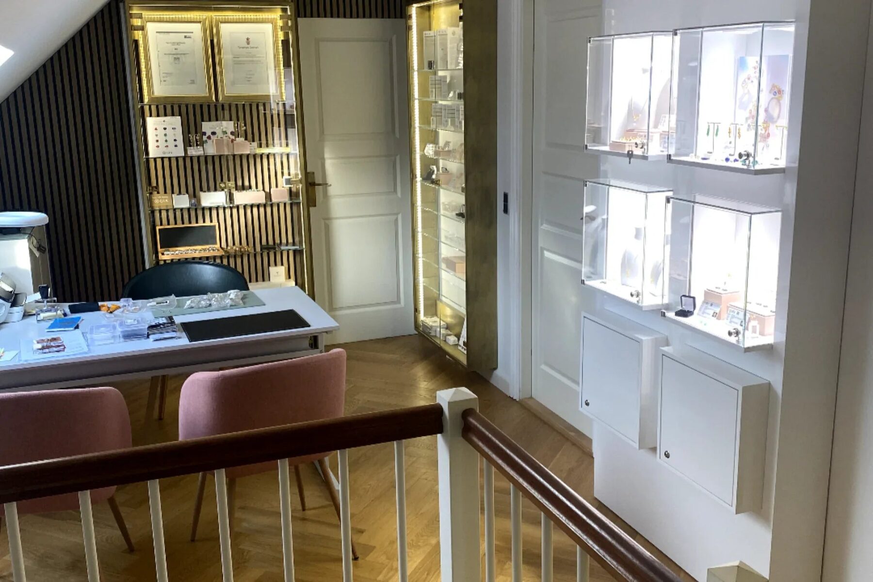 MANICHs showroom med oplyste montrer, indrammede diplomer og et bord til personlig rådgivning