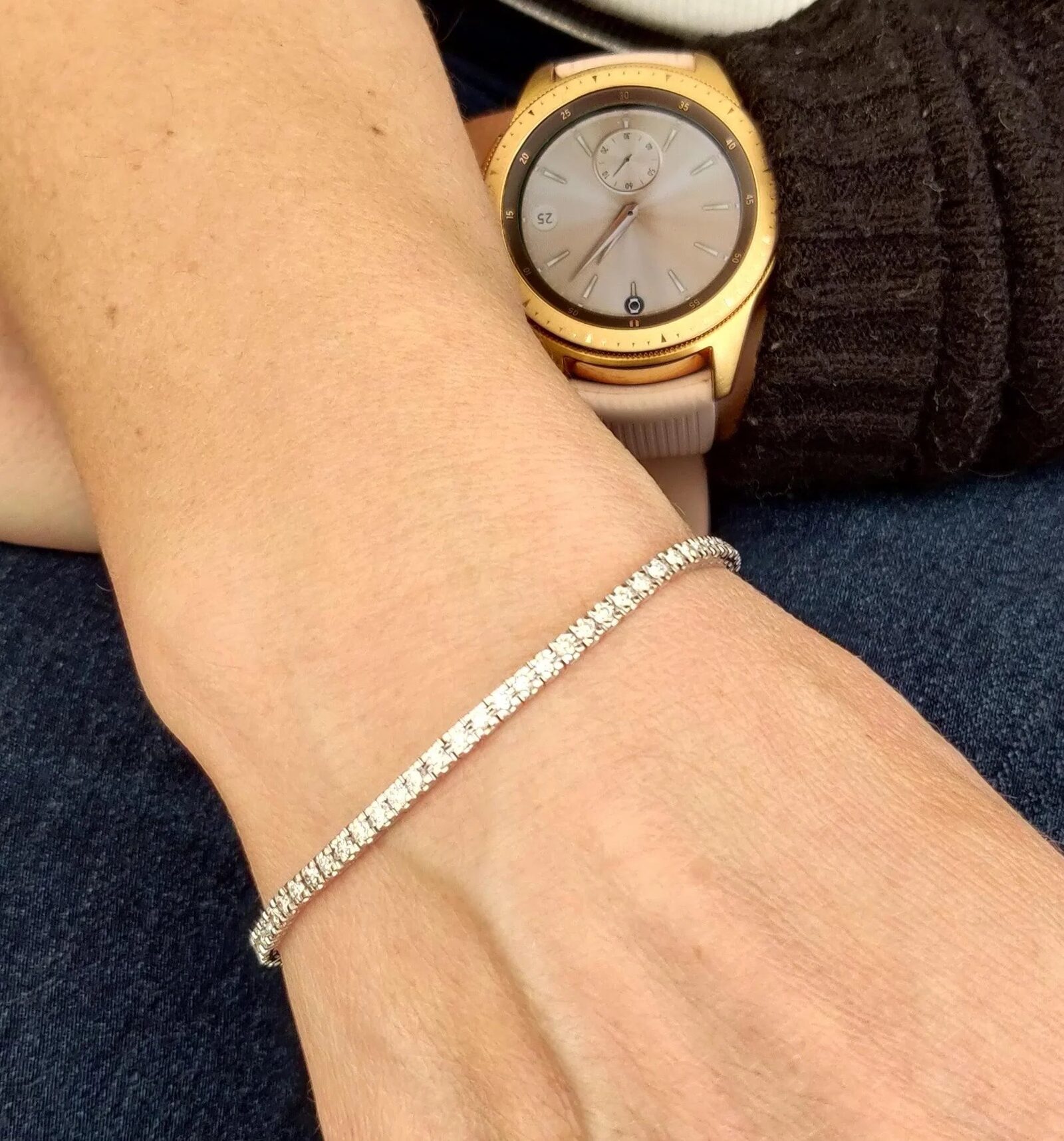 Slankt tennisarmbånd med diamanter båret sammen med et guldur